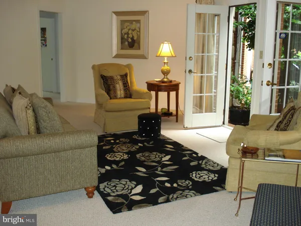 a living room with furniture a window and a potted plant