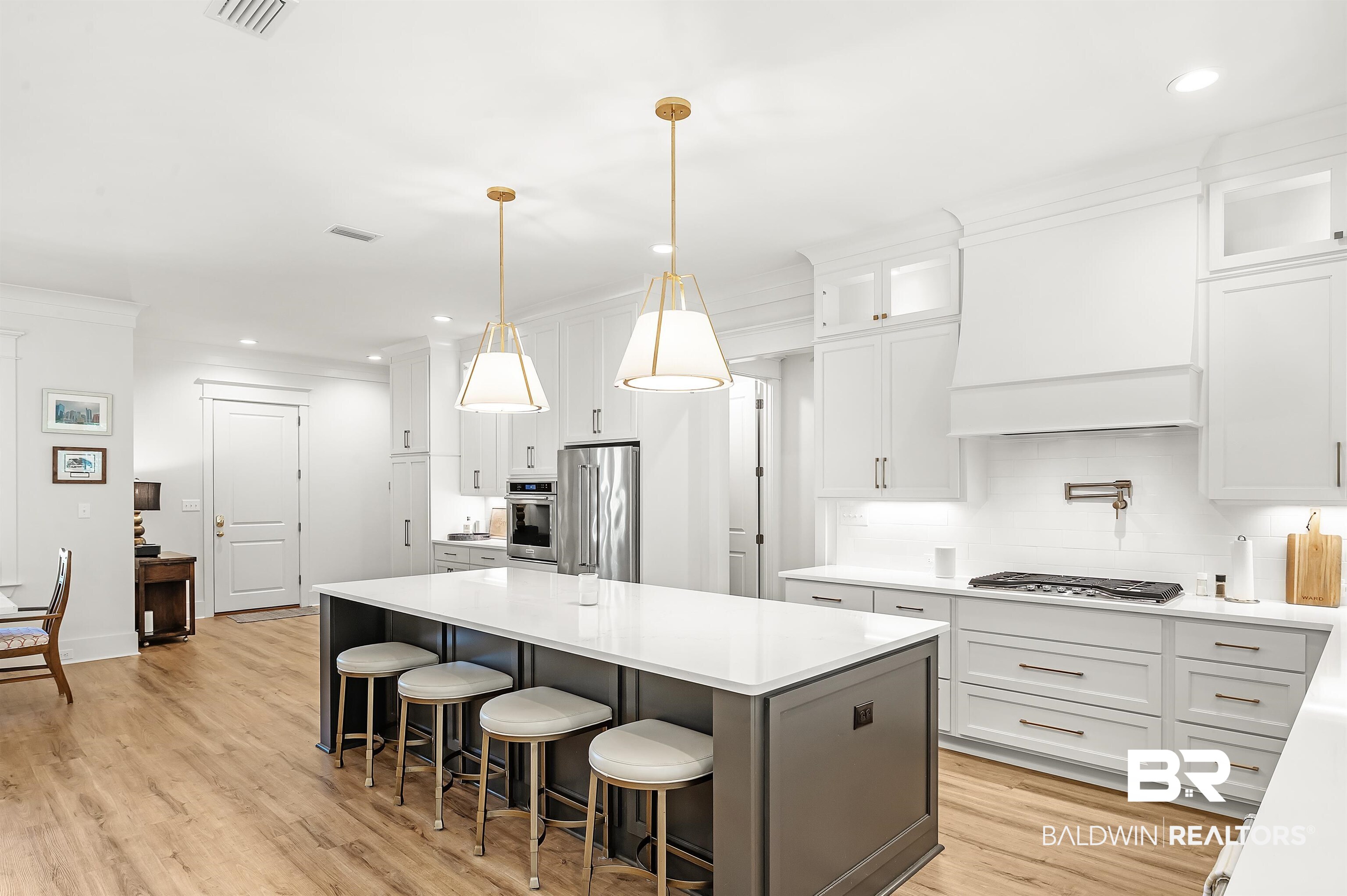 27888 Oakachoy Loop Daphne, AL 36526 - Photo 6 of 65 Kitchen with white cabinetry, a center island, light wood-type flooring, stainless steel appliances, and decorative backsplash