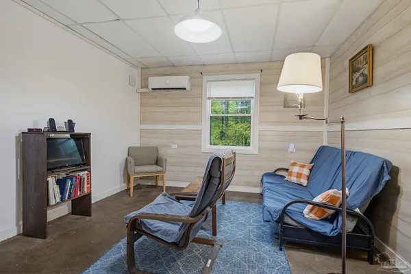 a living room with furniture a window and a flat screen tv