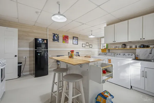 a room with a sink a refrigerator and a stove top oven