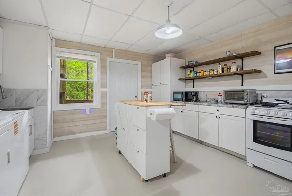 a kitchen with cabinets appliances and a window