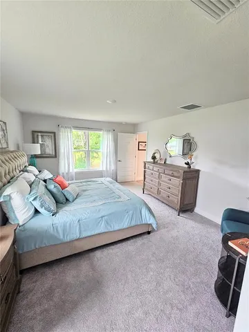 a spacious bedroom with a bed a couch and a window
