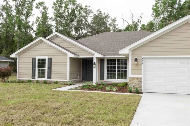 a front view of a house with yard and green space