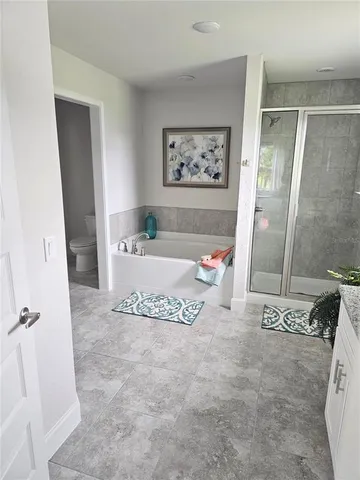 a spacious bedroom with a bed a couch and a window