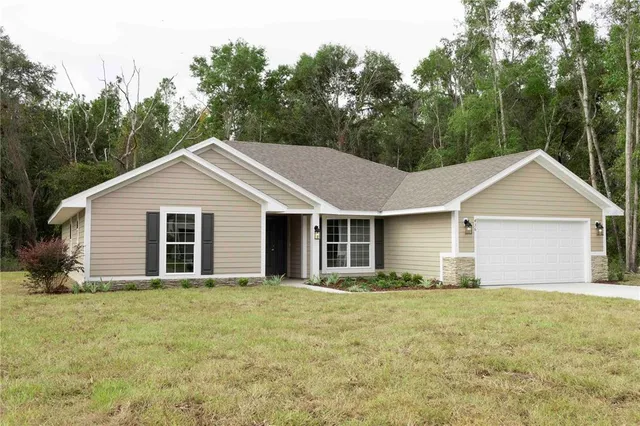 a view of a yard in front of a house with large trees