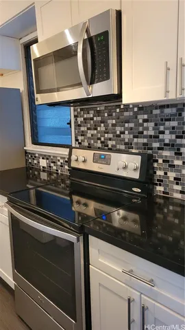 a close view of a stove a microwave and cabinets