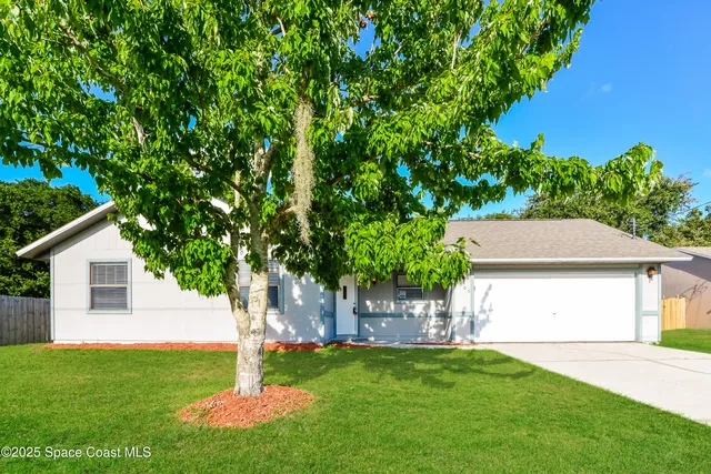a front view of a house with a yard and trees