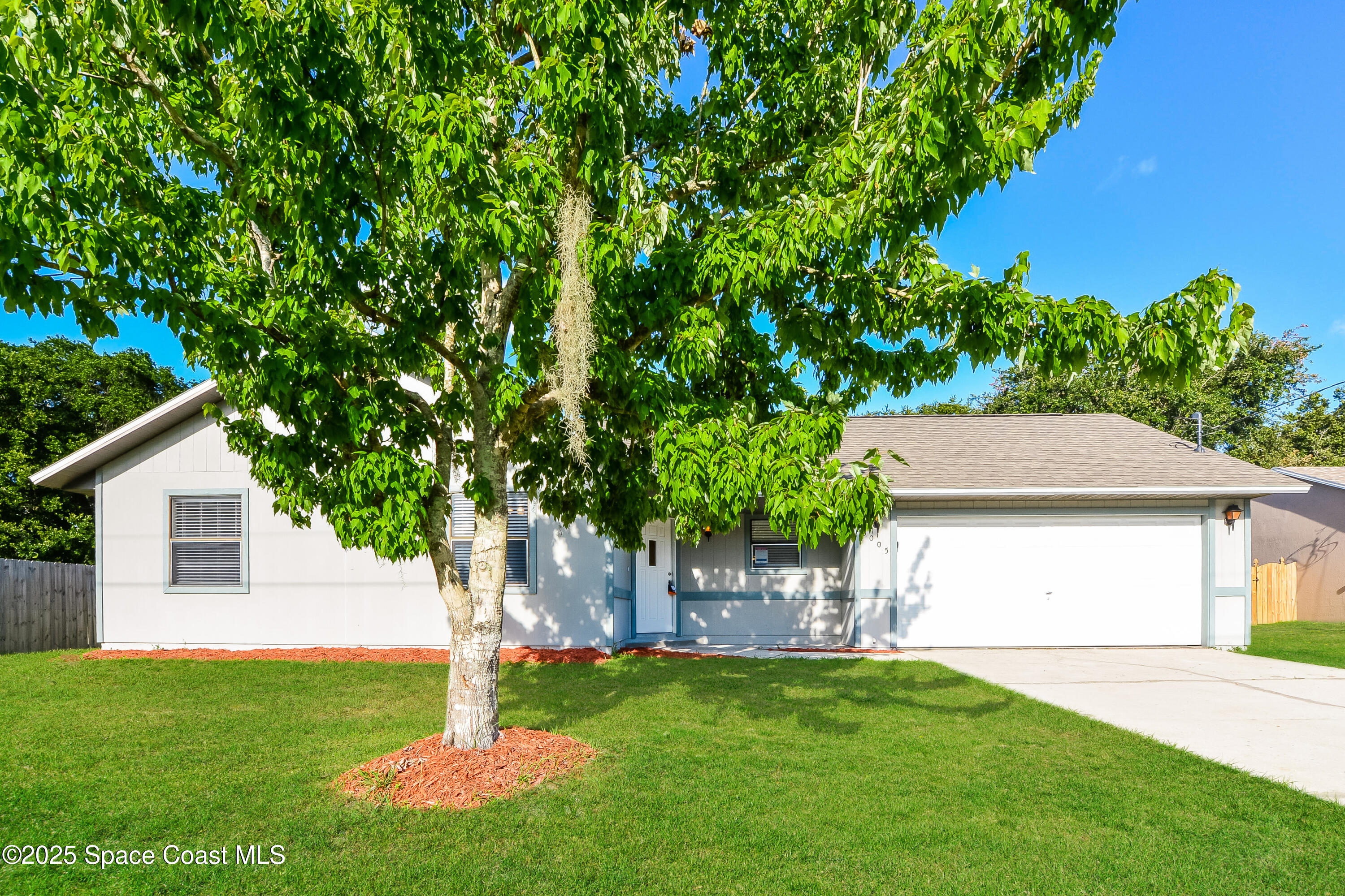 a front view of a house with a yard and trees