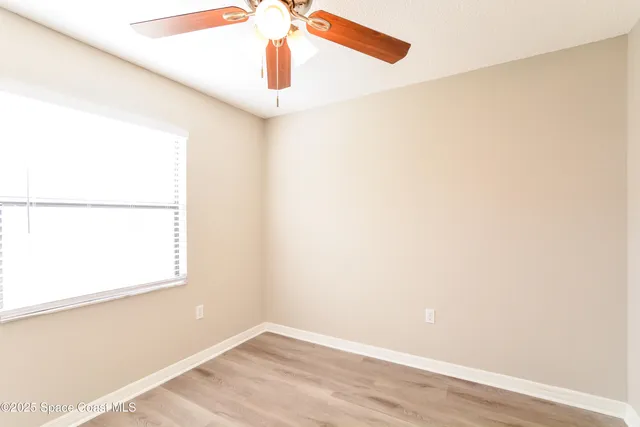 a view of a small space with wooden floor and a window