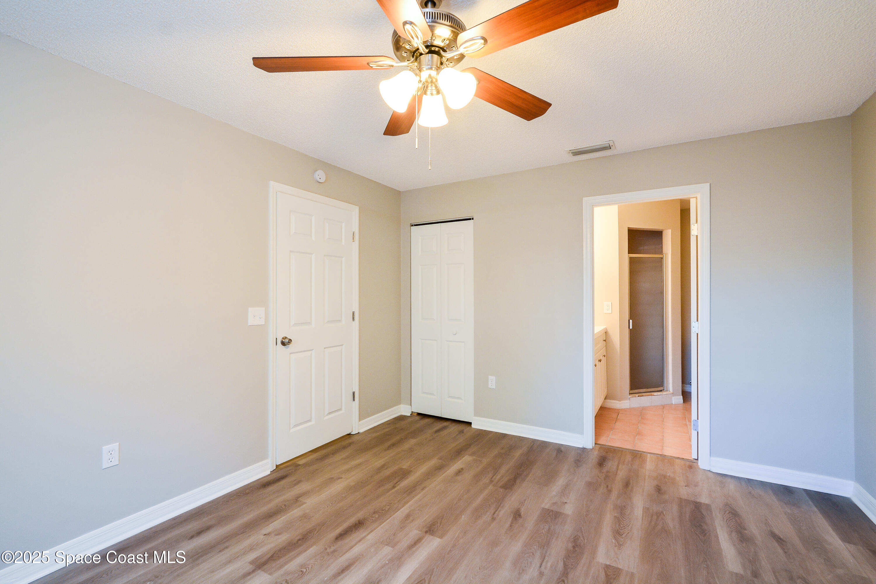 6005 Keystone Avenue Cocoa, FL 32927 - Photo 8 of 16 an empty room with wooden floor closet and ceiling fan