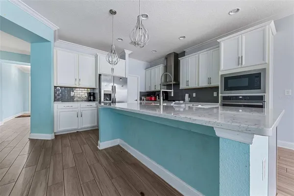 a kitchen with stainless steel appliances granite countertop a sink a stove and cabinets