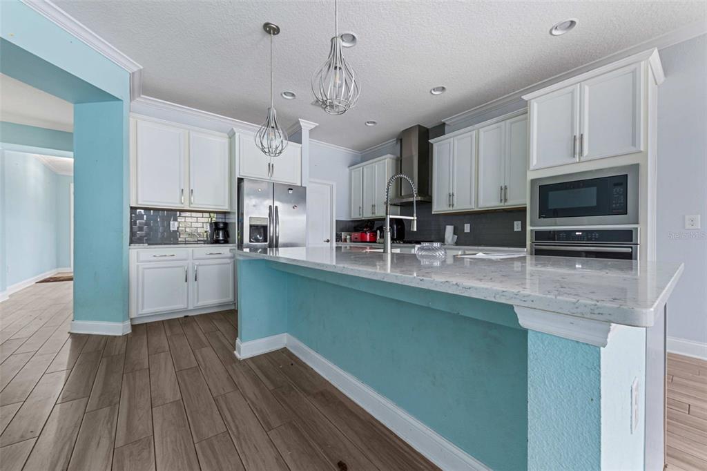 281 Ancona Avenue DeBary, FL 32713 - Photo 12 of 65 a kitchen with stainless steel appliances granite countertop a sink a stove and cabinets
