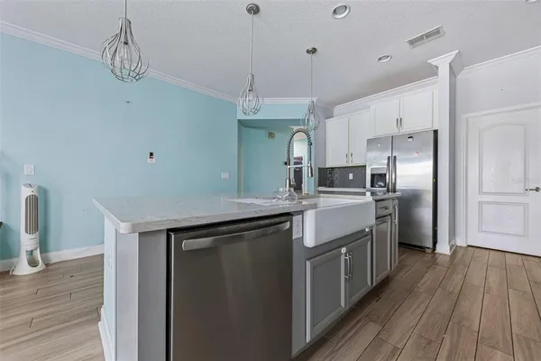 a kitchen with stainless steel appliances granite countertop a kitchen island hardwood floor and a sink