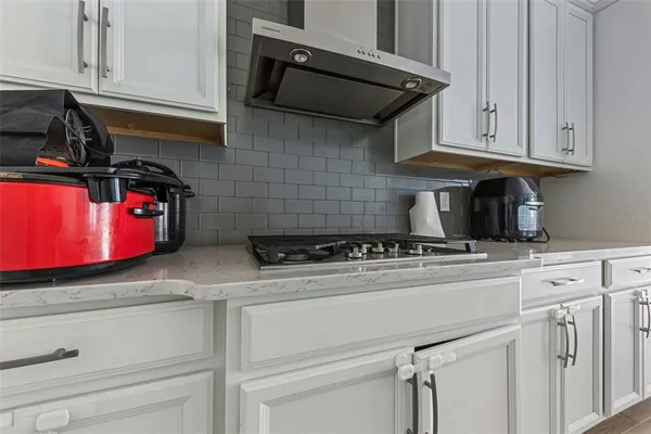 a kitchen with granite countertop cabinets stainless steel appliances and wooden floor