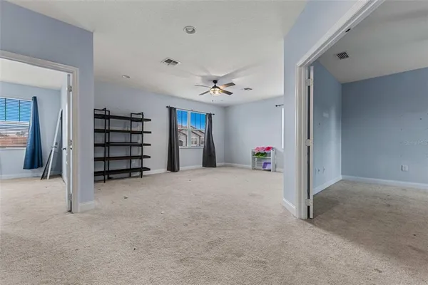 a view of an empty room with a ceiling fan