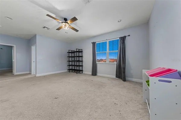 en empty room with windows and ceiling fan