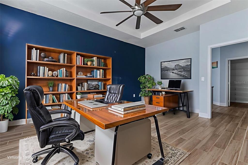 281 Ancona Avenue DeBary, FL 32713 - Photo 3 of 65 a view of a workspace with furniture and a bookshelf