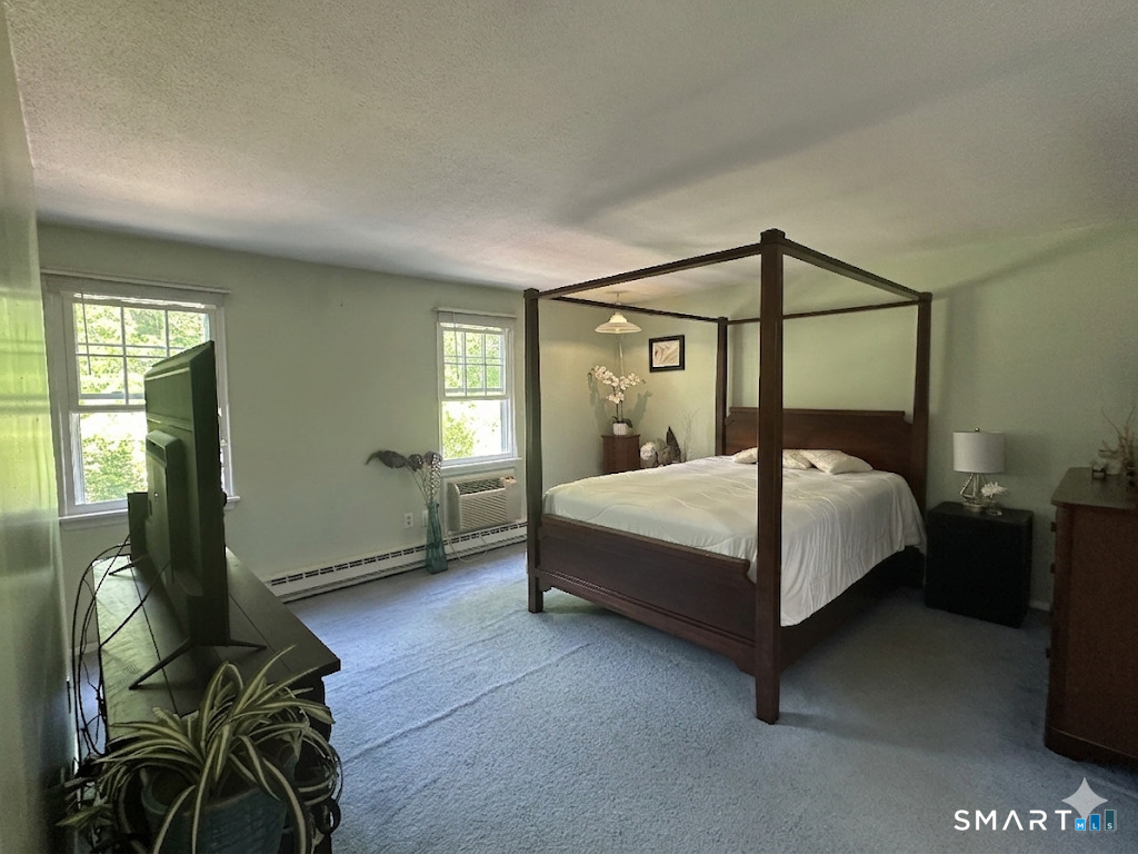 2 Lakeside Drive, Unit M Ledyard, CT 06339 - Photo 19 of 38 a bedroom with a bed table flowerpot and window