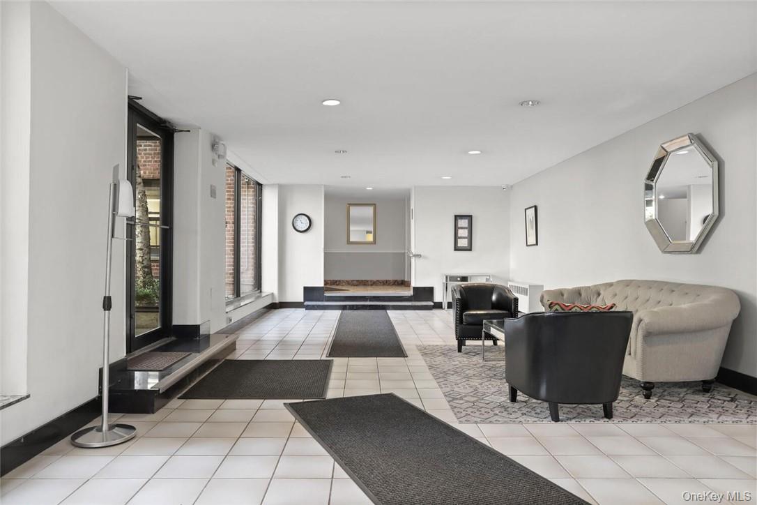10 Franklin Avenue, Unit 1EFF White Plains, NY 10601 - Photo 10 of 13 a living room with a couch and a dining table with wooden floor