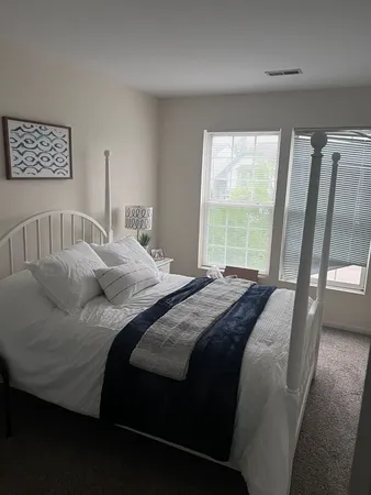 a bedroom with a bed and a large window