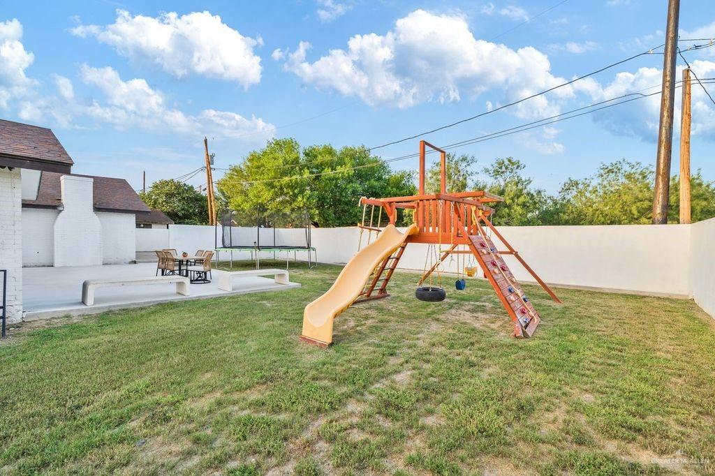 111 South Cox Street Rio Grande City, TX 78582 - Photo 18 of 27 View of jungle gym featuring a trampoline, a fenced backyard, and a patio area