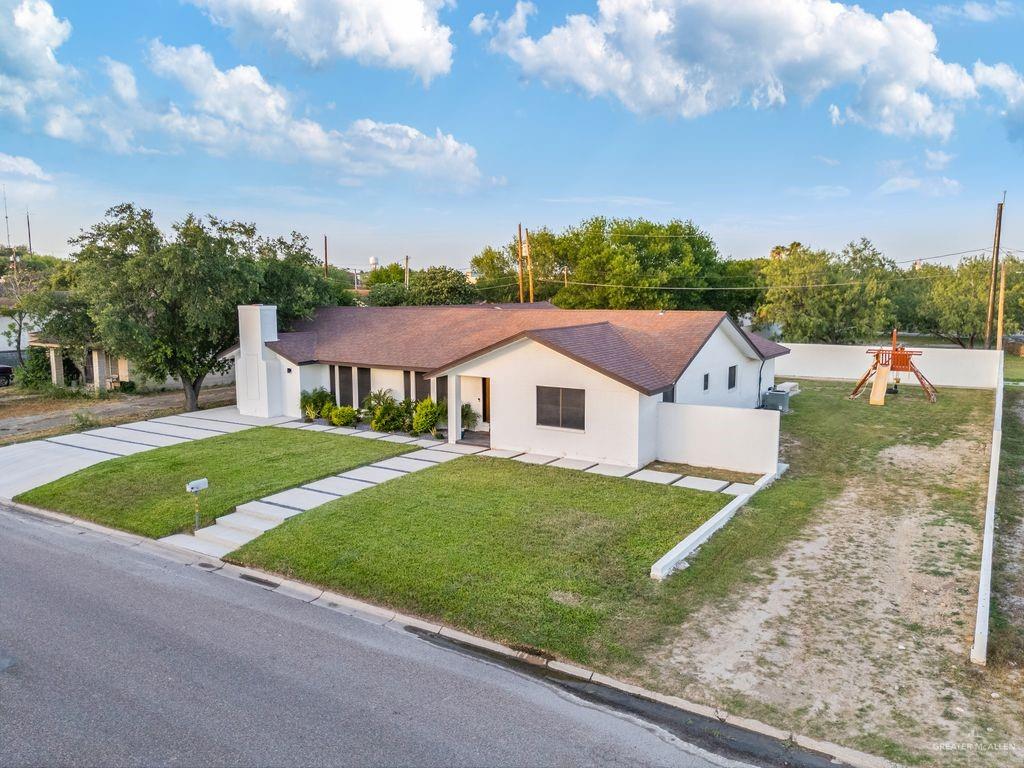 111 South Cox Street Rio Grande City, TX 78582 - Photo 20 of 27 Single story home with driveway, stucco siding, a playground, and a front lawn