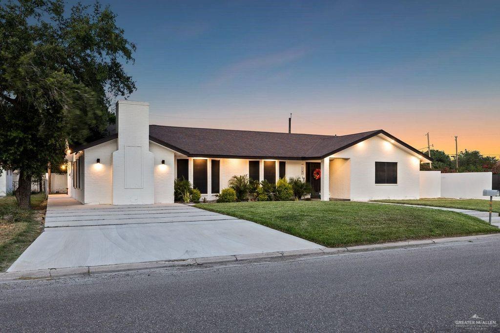 111 South Cox Street Rio Grande City, TX 78582 - Photo 3 of 27 View of front facade with a yard, a chimney, driveway, and brick siding