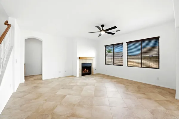 an empty room with windows and fireplace