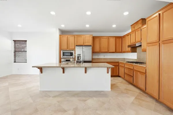 a view of kitchen with stainless steel appliances kitchen island microwave and cabinets