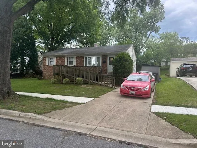 a front view of a house with a garden and trees