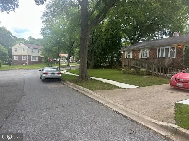 a car parked in front of a house next to a yard