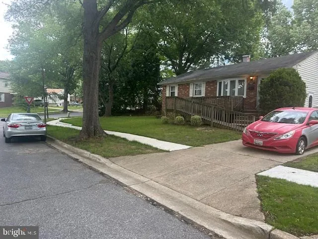 a front view of a house with a garden and parking