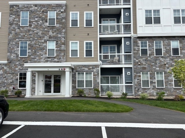 4 Stratton Drive, Unit 301 Woburn, MA 01801 - Photo 2 of 24 a front view of a house with a yard