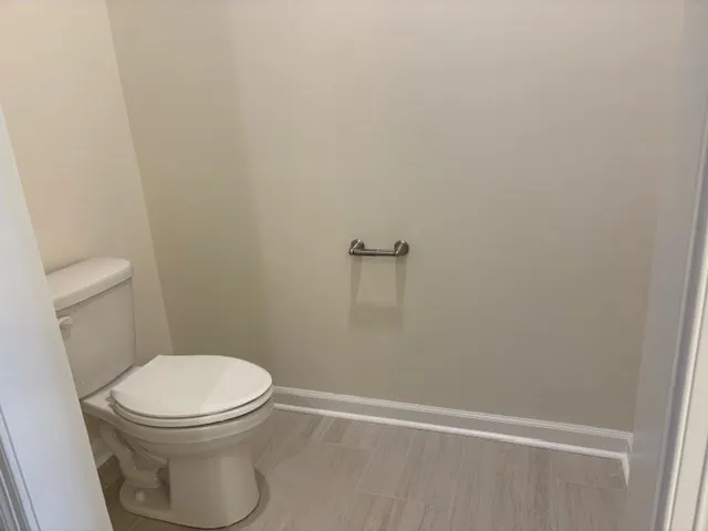 a white toilet sitting next to a shower