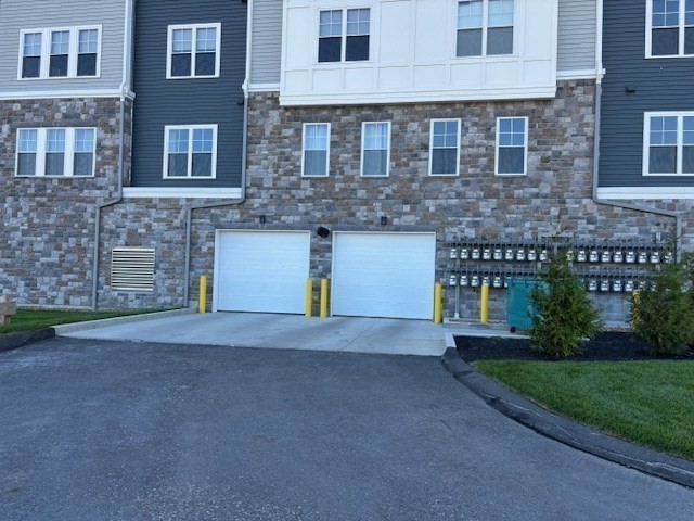 4 Stratton Drive, Unit 301 Woburn, MA 01801 - Photo 4 of 24 a front view of a house with a yard and a garage