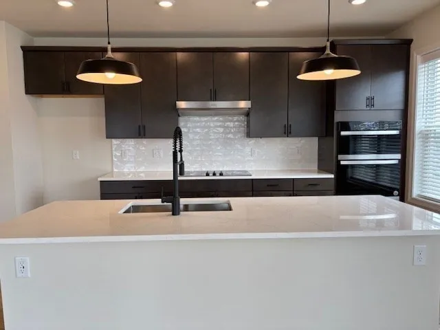 a kitchen with stainless steel appliances a table and chairs