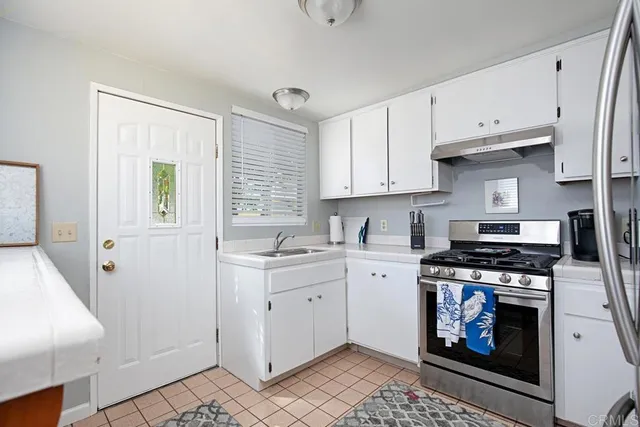 a kitchen with stainless steel appliances a stove a sink and a refrigerator