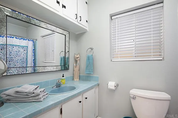a bathroom with a granite countertop sink and a toilet