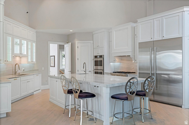 3222 Eagle View Circle Sandy, UT 84092 - Photo 15 of 60 Kitchen with backsplash, stainless steel appliances, light wood finished floors, light stone counters, and recessed lighting