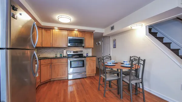 a kitchen with stainless steel appliances granite countertop a refrigerator a stove a sink and a microwave