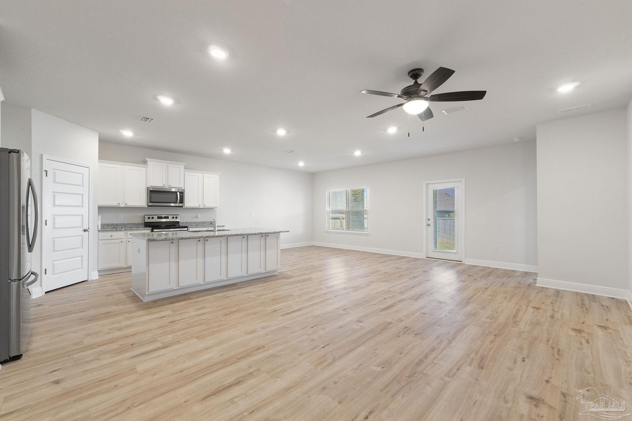 7737 Burnside Loop Pensacola, FL 32526 - Photo 7 of 33 a kitchen with kitchen island white cabinets and stainless steel appliances