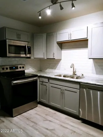 a kitchen with granite countertop cabinets stainless steel appliances and a sink