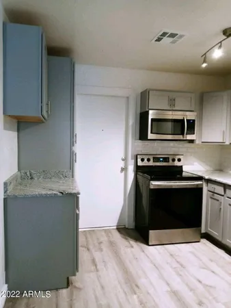 a kitchen with granite countertop a stove and a microwave