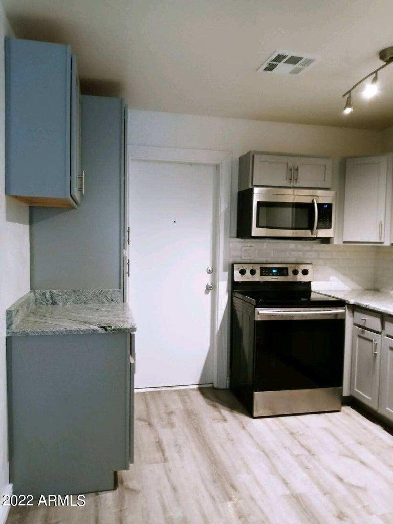 6713 East Cheery Lynn Road, Unit 2 Scottsdale, AZ 85251 - Photo 6 of 8 a kitchen with granite countertop a stove and a microwave