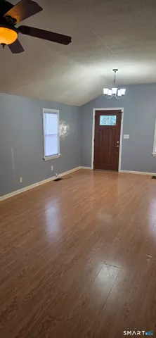 a view of an empty room with wooden floor