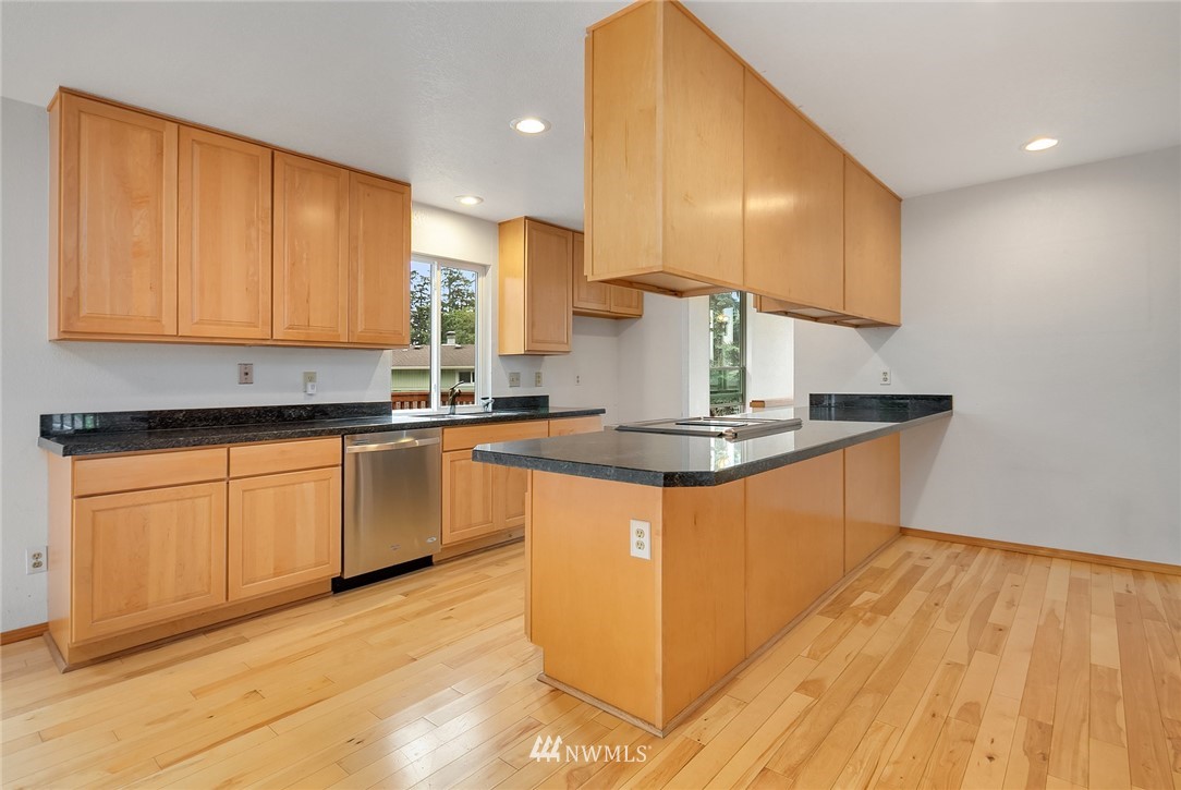 521 South 28th Place Renton, WA 98055 - Photo 4 of 20 a kitchen with stainless steel appliances granite countertop a sink a stove a refrigerator cabinets and wooden floor