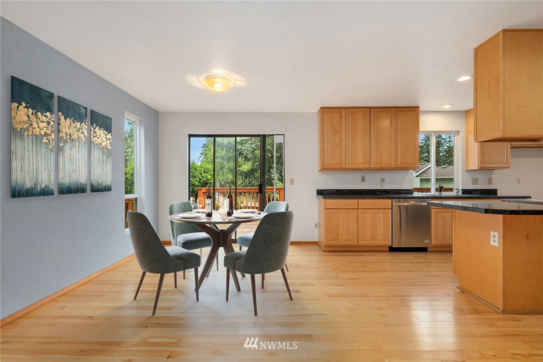 521 South 28th Place Renton, WA 98055 - Photo 5 of 20 a kitchen with granite countertop a stove a sink a dining table and chairs