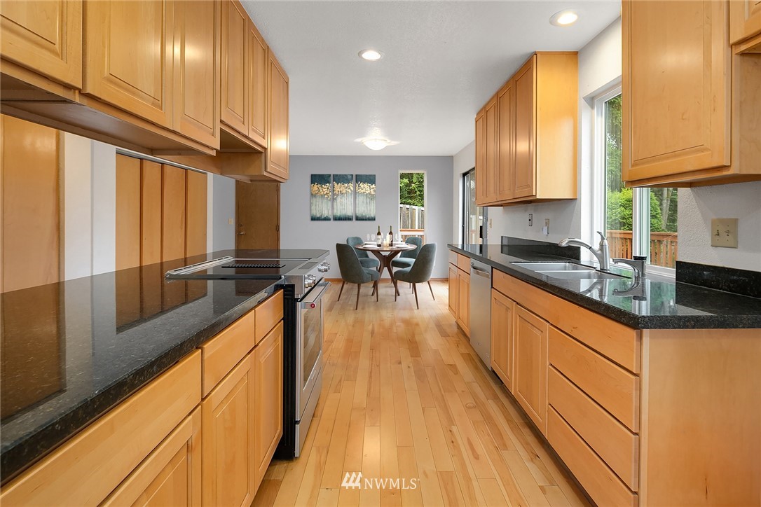 521 South 28th Place Renton, WA 98055 - Photo 6 of 20 a view of a kitchen with kitchen island granite countertop a large window a sink and counter space