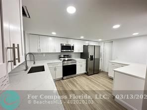 Undisclosed Address Fort Lauderdale, FL 33319 - Photo 2 of 19 a kitchen with a refrigerator a sink and a stove top oven