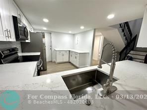 Undisclosed Address Fort Lauderdale, FL 33319 - Photo 3 of 19 a kitchen with stainless steel appliances kitchen island granite countertop a sink and cabinets